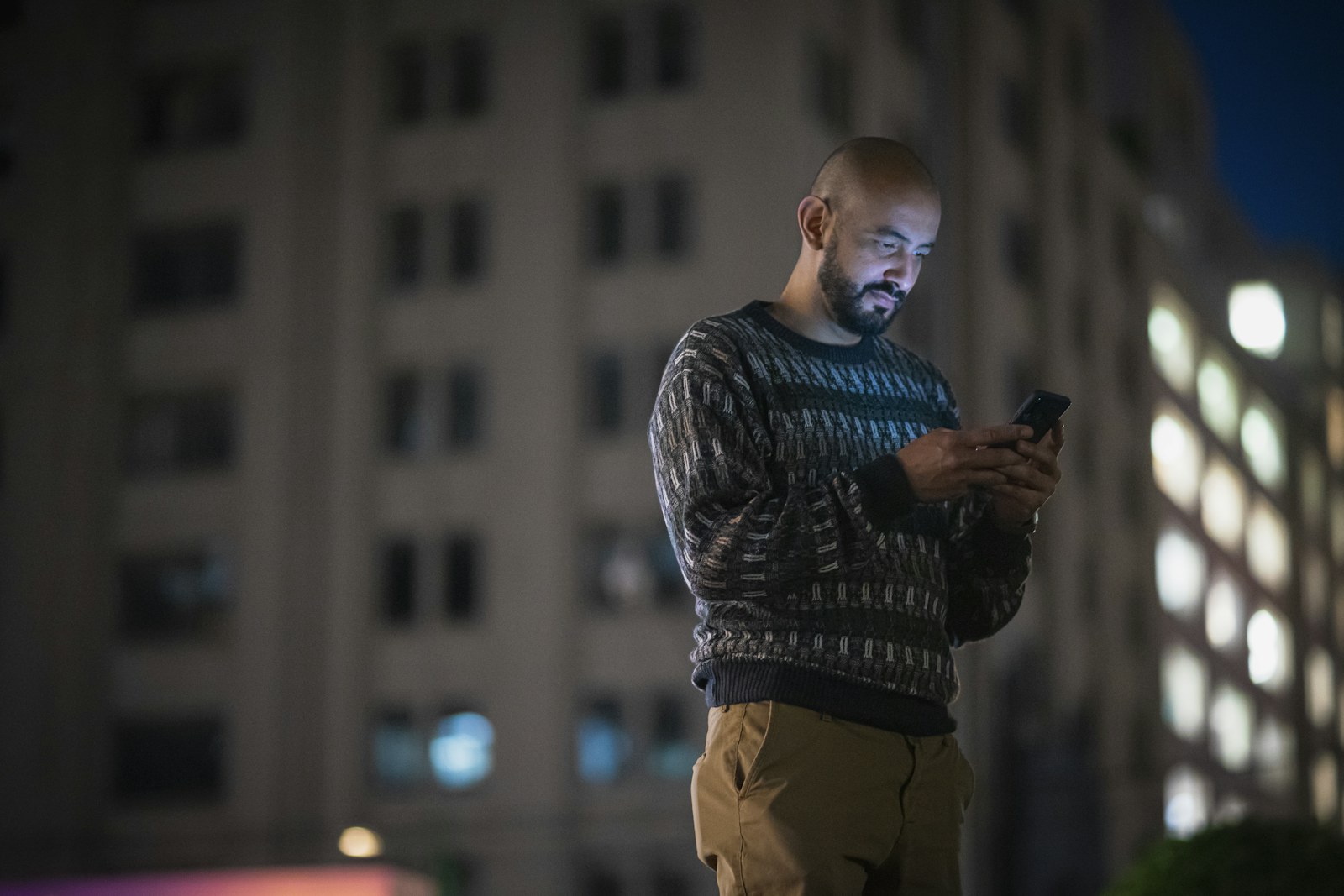 A person checking the Femtoplay app on their phone in the city